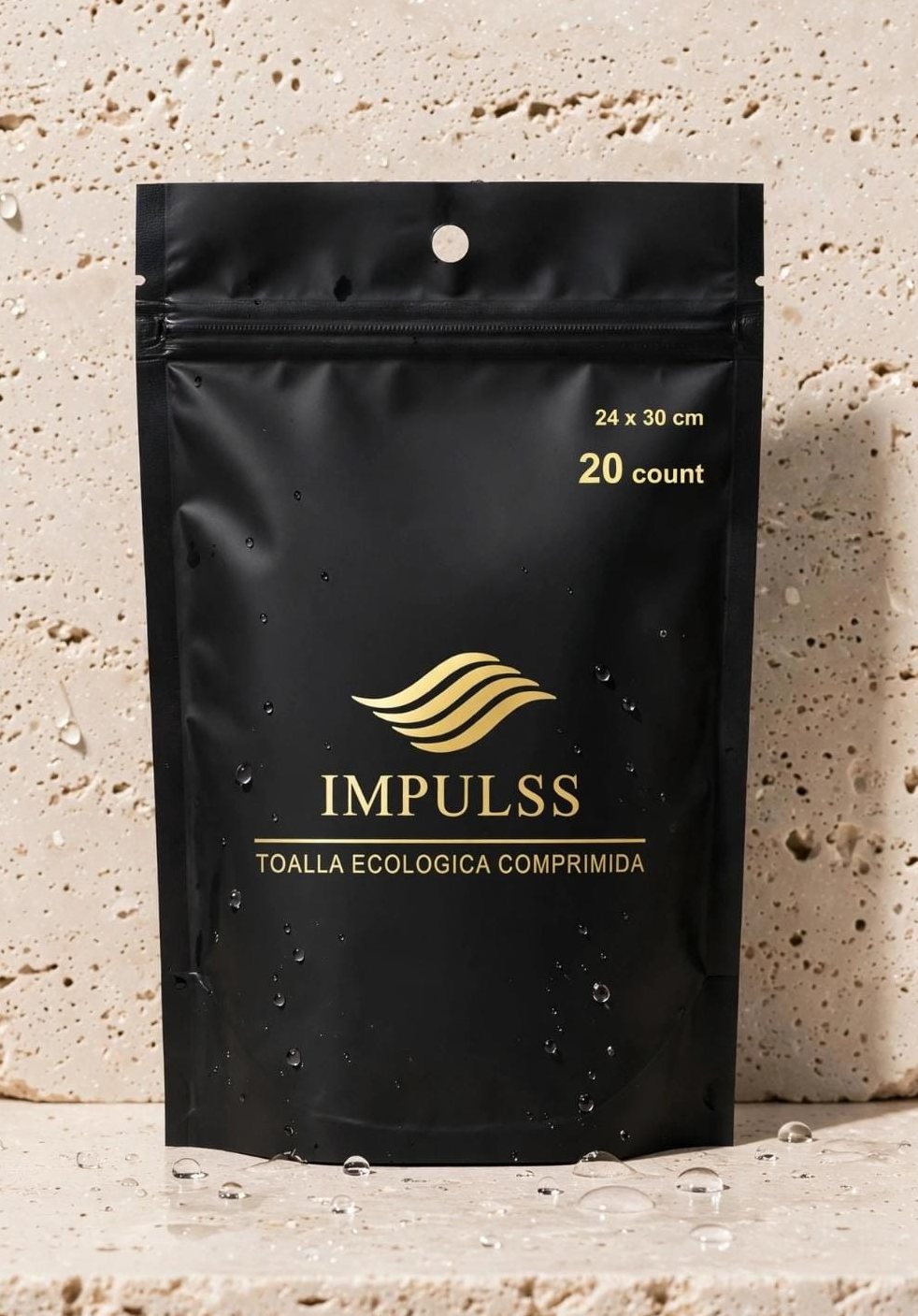 Bolsa negra IMPULSS de 20 toallitas comprimidas sobre travertino